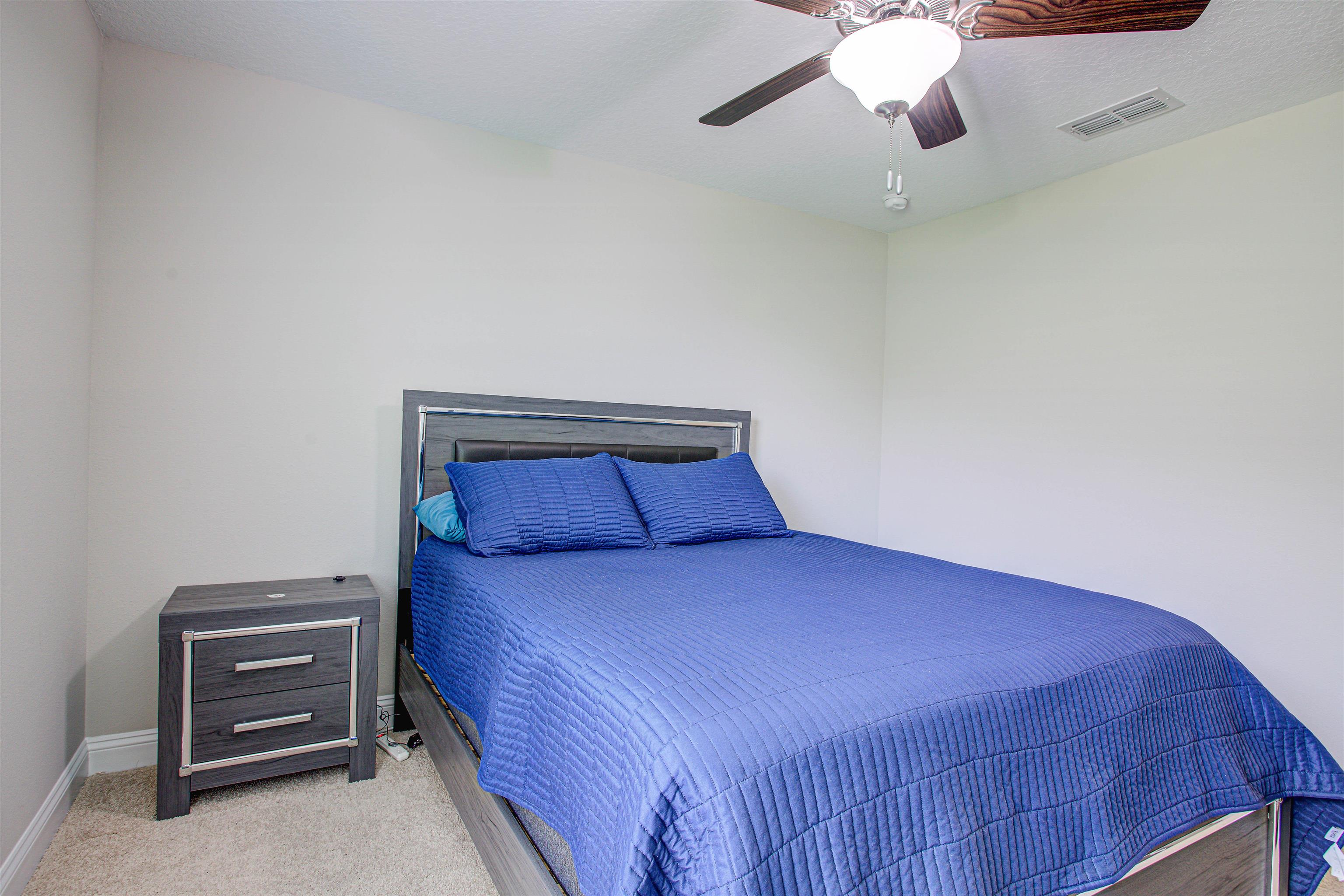 721 Narvarez Avenue St. Augustine, FL 32084 - Photo 26 of 59 Bedroom featuring carpet flooring, a textured ceiling, and a ceiling fan