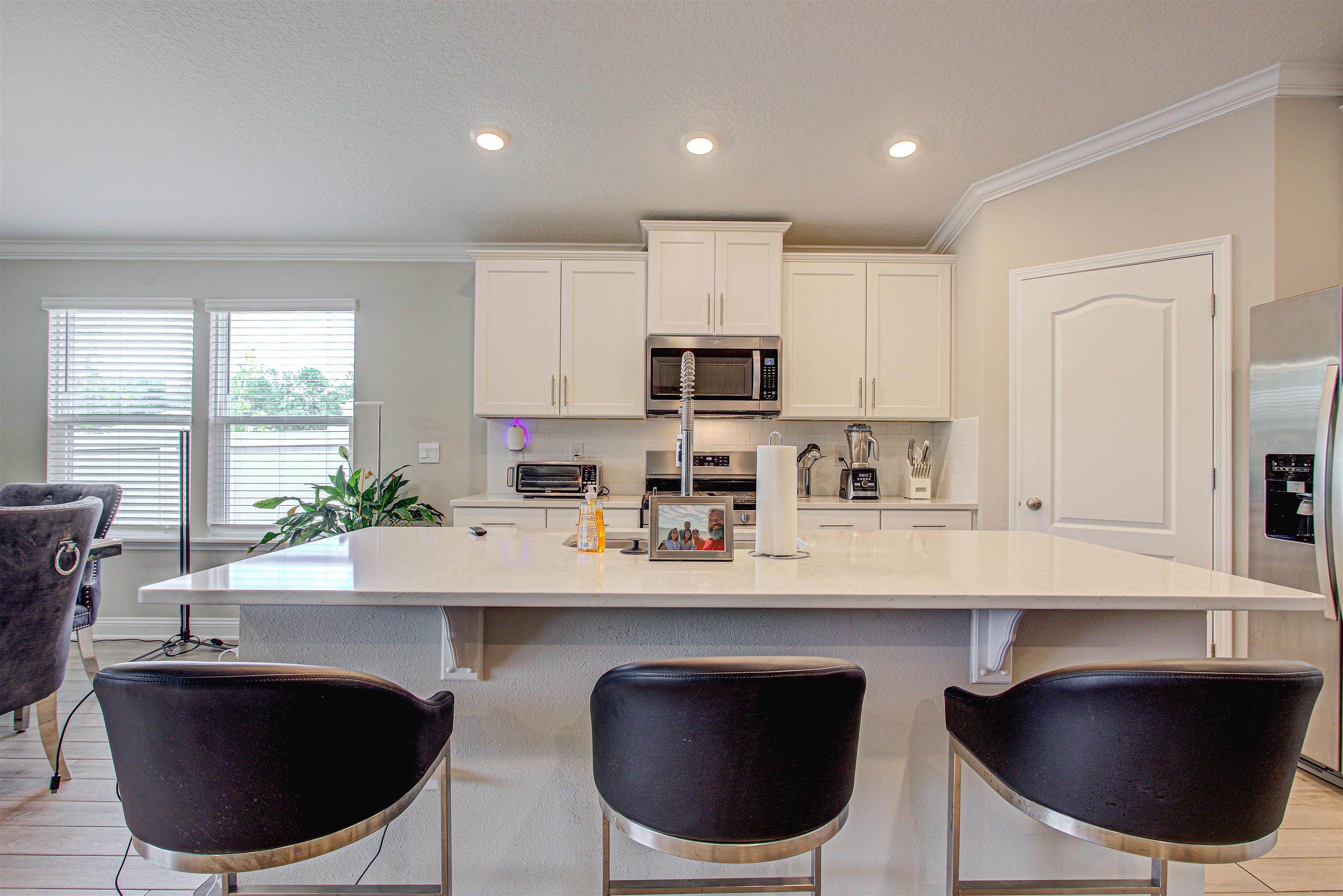 721 Narvarez Avenue St. Augustine, FL 32084 - Photo 49 of 59 Kitchen with recessed lighting, a breakfast bar area, white cabinetry, stainless steel appliances, and a kitchen island with sink