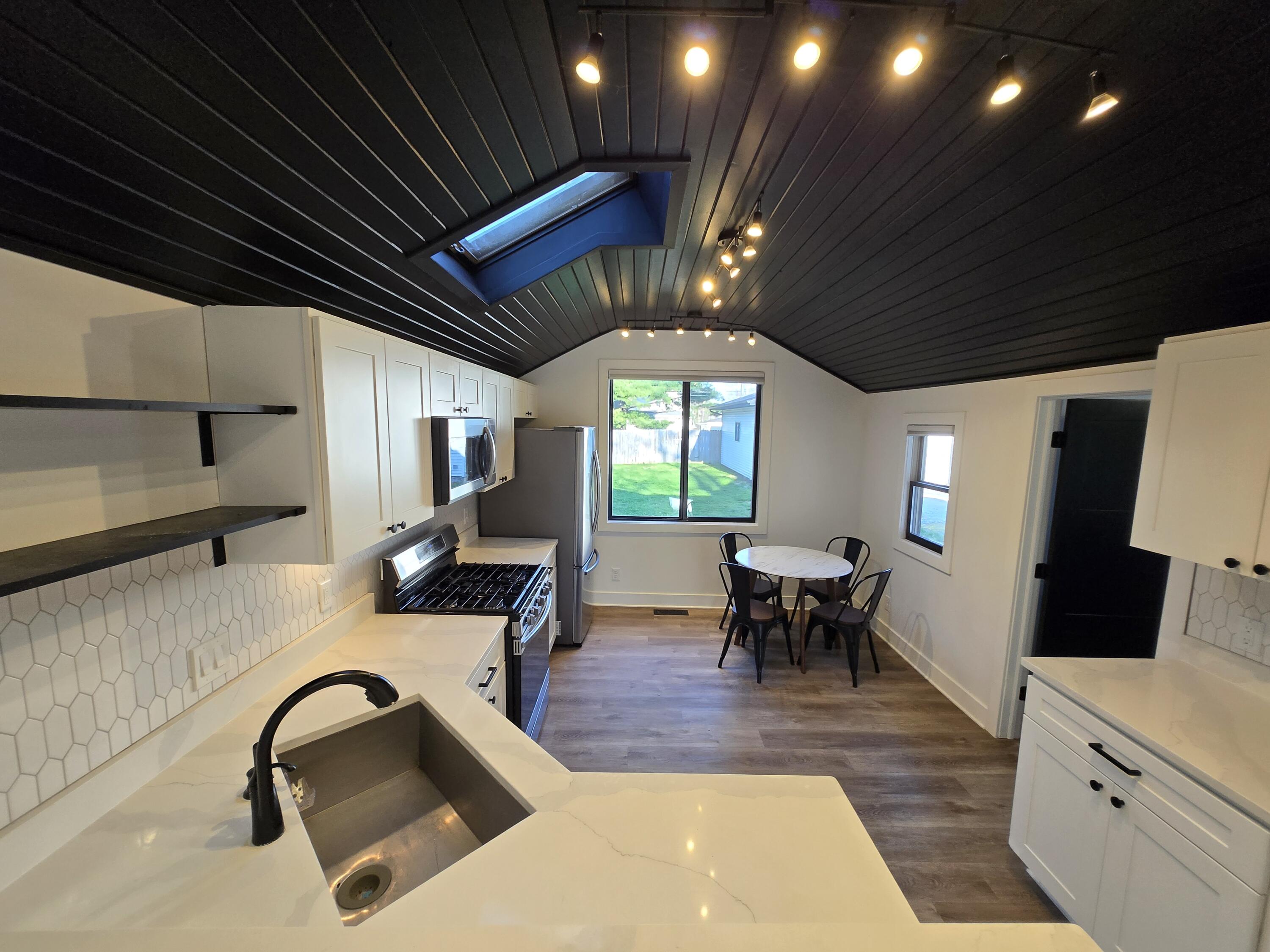 506 Locust Street Valparaiso, IN 46383 - Photo 7 of 34 a view of a kitchen with kitchen island stainless steel appliances wooden floor dining table and chairs