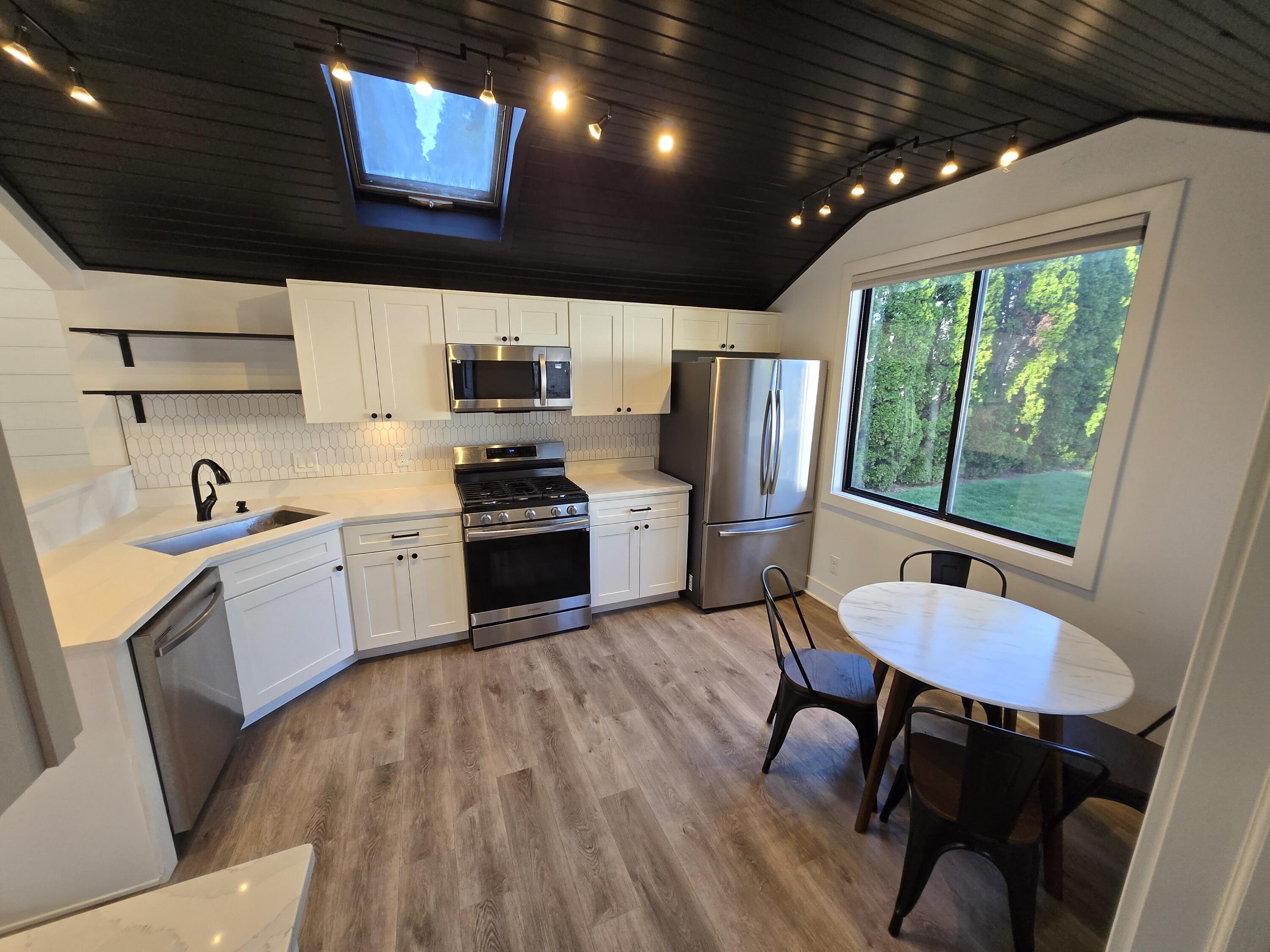 506 Locust Street Valparaiso, IN 46383 - Photo 9 of 34 a kitchen with stainless steel appliances granite countertop a refrigerator a sink dishwasher a stove a dining table and chairs with wooden floor