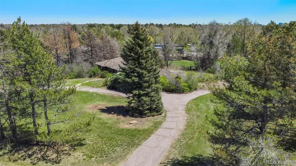 an aerial view of residential house with outdoor space and trees all around