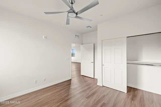 a view of empty room with wooden floor and window