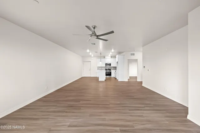 a view of empty room with wooden floor