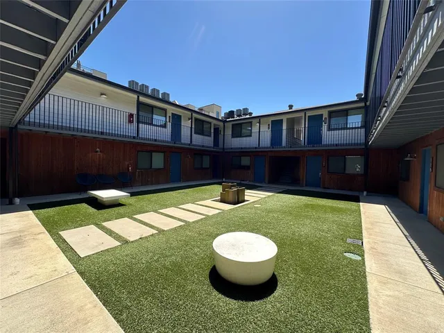 a backyard of a house with fountain table and chairs
