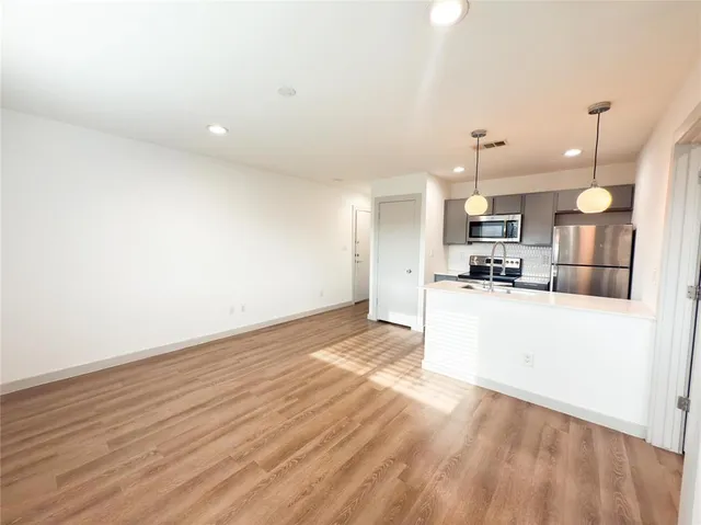 a view of large kitchen with wooden floor and window