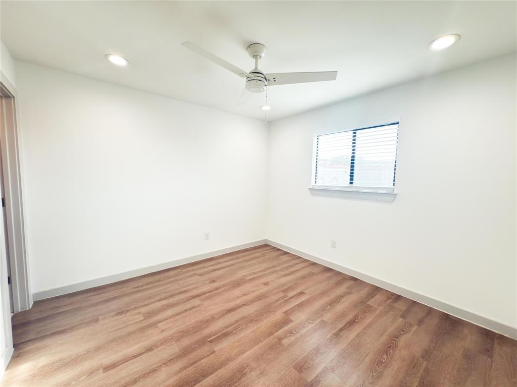4526 Munger Avenue, Unit 208 Dallas, TX 75204 - Photo 10 of 19 an empty room with wooden floor ceiling fan and windows