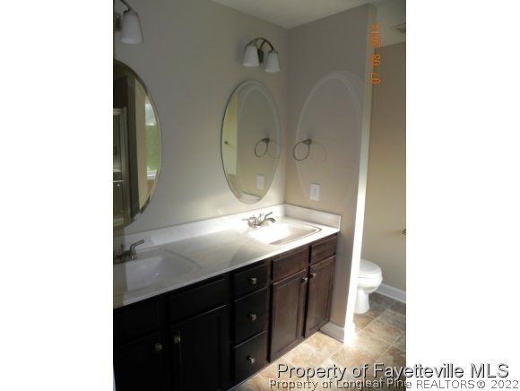 2651 Rockfish Road Raeford, NC 28376 - Photo 19 of 21 a bathroom with a sink a toilet and a mirror