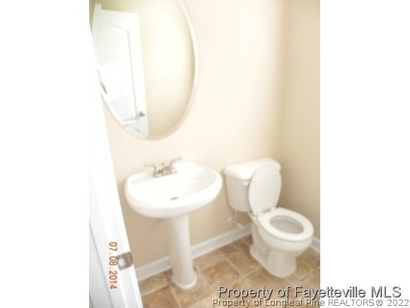 2651 Rockfish Road Raeford, NC 28376 - Photo 4 of 21 a bathroom with a toilet a sink and a mirror