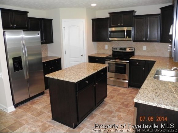 2651 Rockfish Road Raeford, NC 28376 - Photo 5 of 21 a kitchen with stainless steel appliances granite countertop a refrigerator a stove top oven a sink and dishwasher