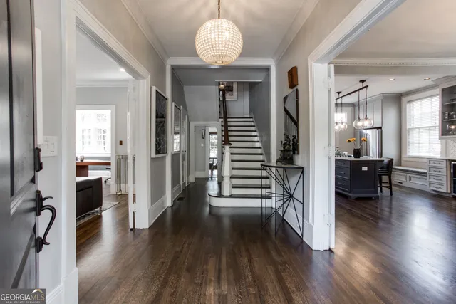 a kitchen with stainless steel appliances a dining table chairs stove and wooden floor
