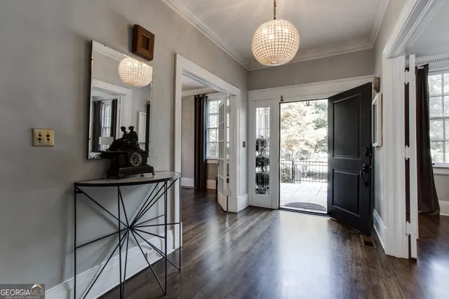 a kitchen with stainless steel appliances granite countertop a stove a refrigerator a kitchen island a dining table and chairs with wooden floor