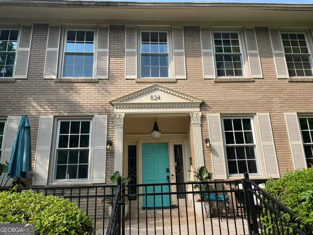 a view of a room with wooden floor clock and a window
