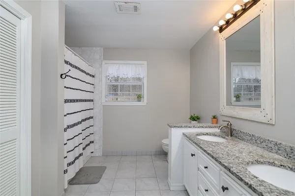 a bathroom with a granite countertop sink and mirror