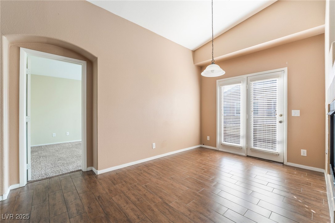 1570 Rusty Ridge Lane Henderson, NV 89002 - Photo 6 of 35 Empty room with dark wood-type flooring, baseboards, and vaulted ceiling