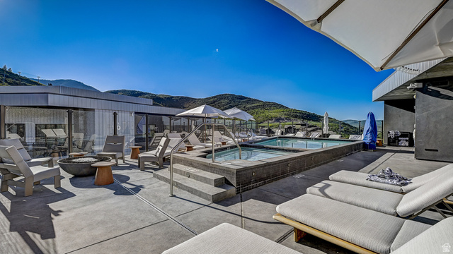 2417 West High Road, Unit 2515 Park City, UT 84098 - Photo 34 of 67 View of patio / terrace with an outdoor fire pit, a mountain view, and a community pool