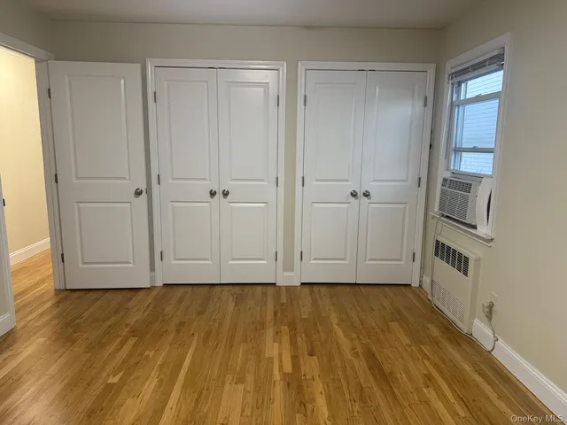 a view of a room with wooden floor closet and windows