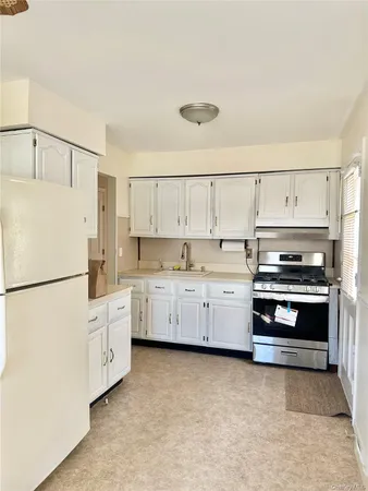 a kitchen with white cabinets and white appliances