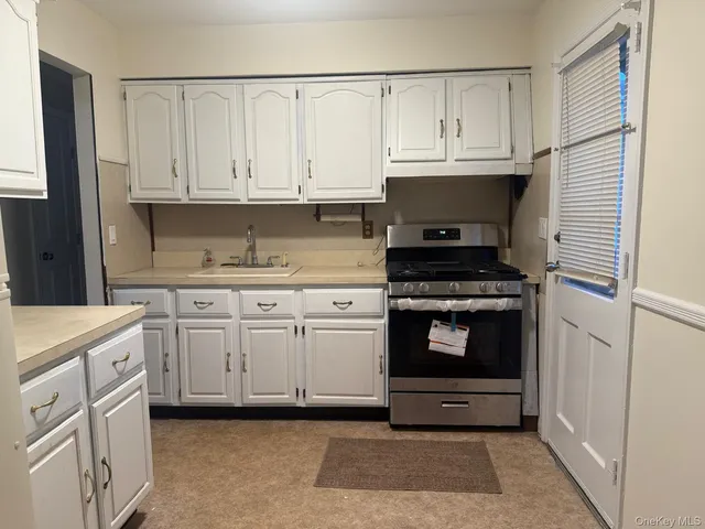 a kitchen with white cabinets and appliances
