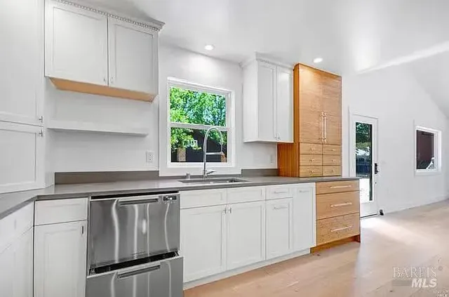 a kitchen with granite countertop white cabinets and white appliances