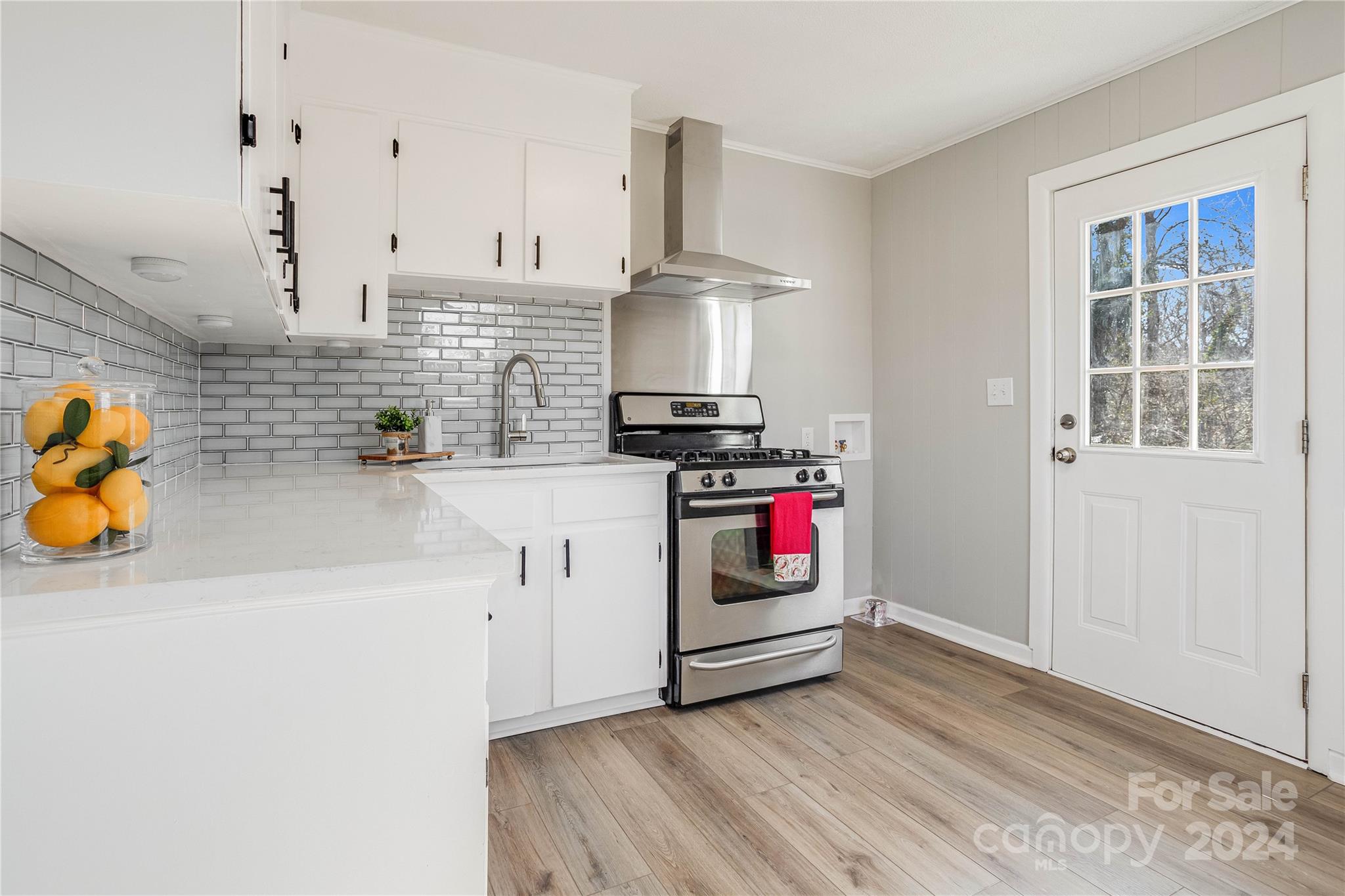 410 Holly Hills Road Dallas, NC 28034 - Photo 7 of 27 a kitchen with stainless steel appliances a stove a sink and white cabinets
