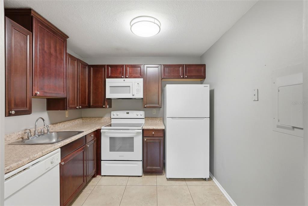 11709 Raintree Village Boulevard, Unit C Temple Terrace, FL 33617 - Photo 5 of 23 a kitchen with a white stove top oven and sink