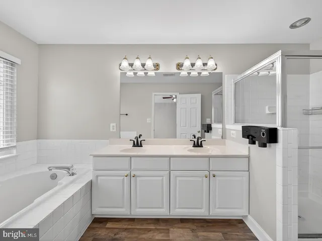 a bathroom with a sink a toilet a mirror and shower