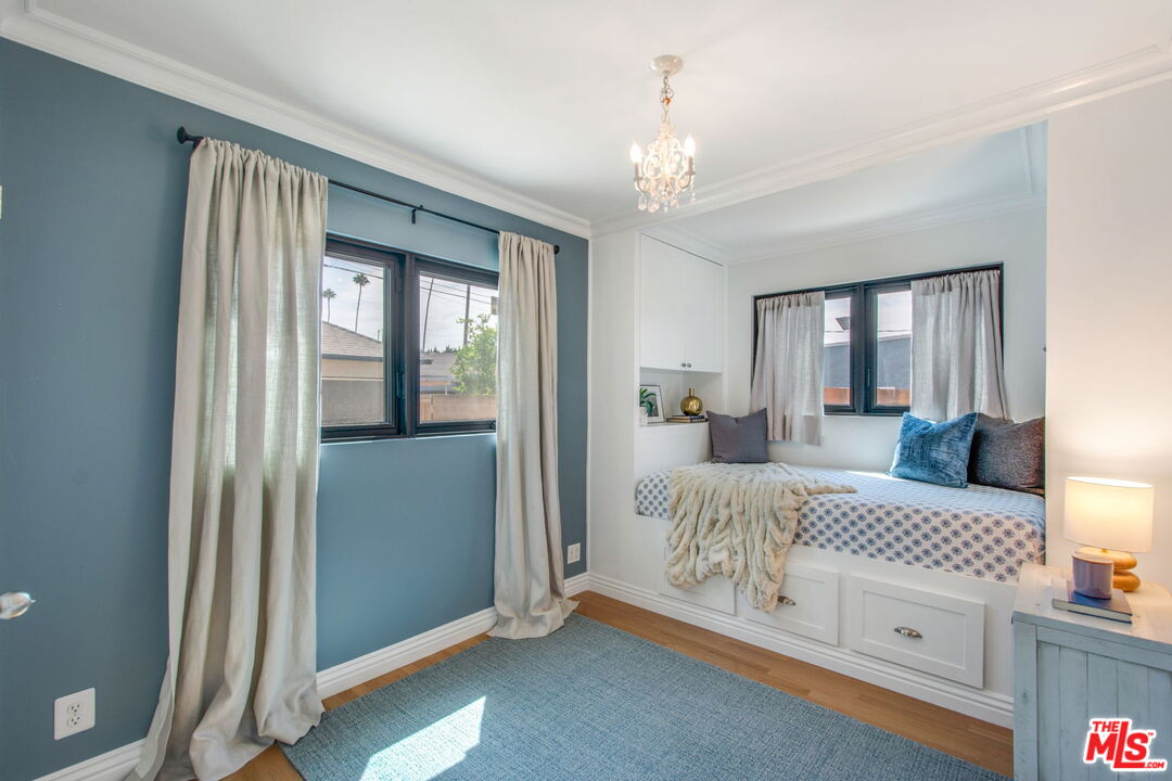 3558 Muirfield Road South Los Angeles, CA 90016 - Photo 12 of 23 a bedroom with a large bed and a chandelier