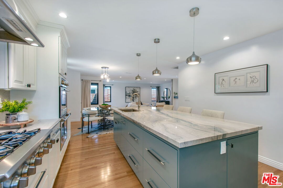3558 Muirfield Road South Los Angeles, CA 90016 - Photo 20 of 23 a large kitchen with kitchen island a stove a sink a table and chairs