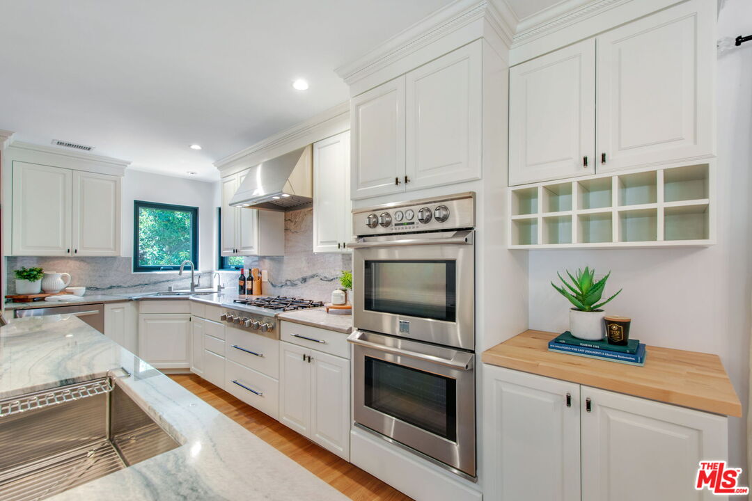 3558 Muirfield Road South Los Angeles, CA 90016 - Photo 5 of 23 a kitchen with granite countertop a sink a stove and cabinets