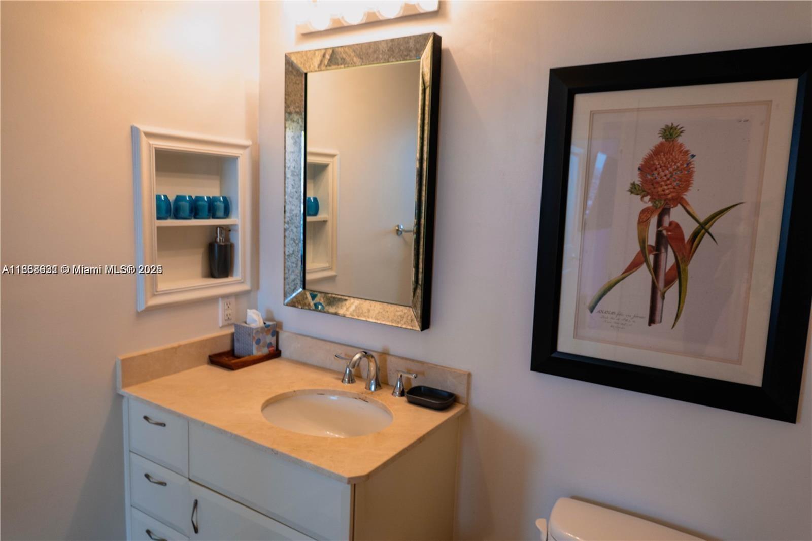6365 Collins Avenue, Unit 2710 Miami Beach, FL 33141 - Photo 12 of 24 a bathroom with a sink and a mirror