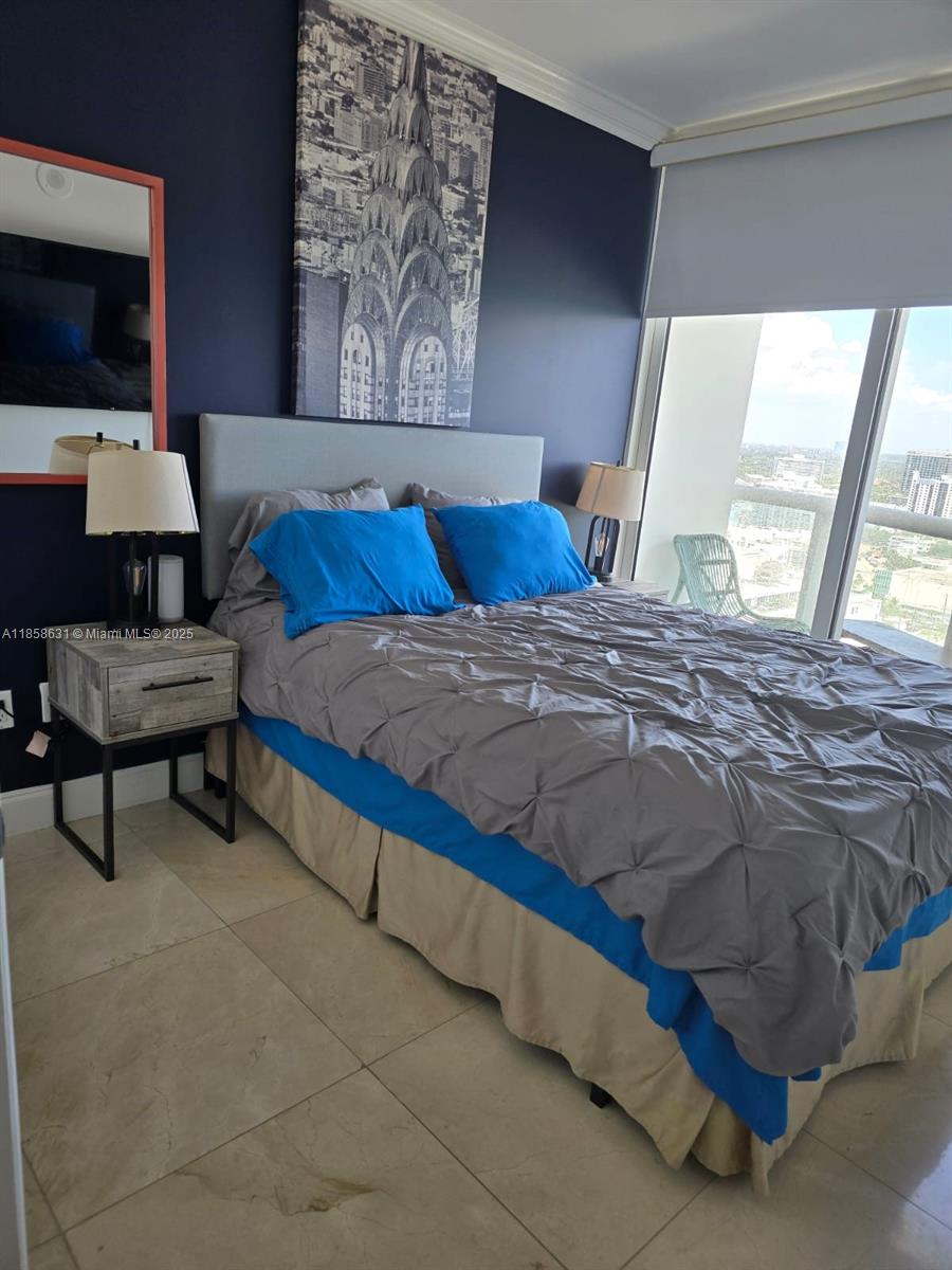 6365 Collins Avenue, Unit 2710 Miami Beach, FL 33141 - Photo 13 of 24 a bedroom with a bed and a flat screen tv