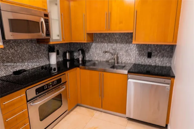 a kitchen with stainless steel appliances granite countertop a stove a sink and a microwave