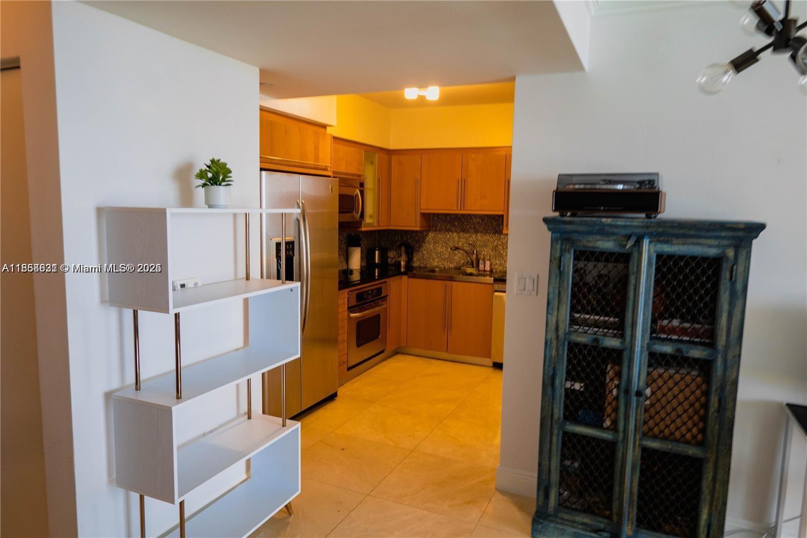 6365 Collins Avenue, Unit 2710 Miami Beach, FL 33141 - Photo 20 of 24 a living room with stainless steel appliances furniture stove and a kitchen view