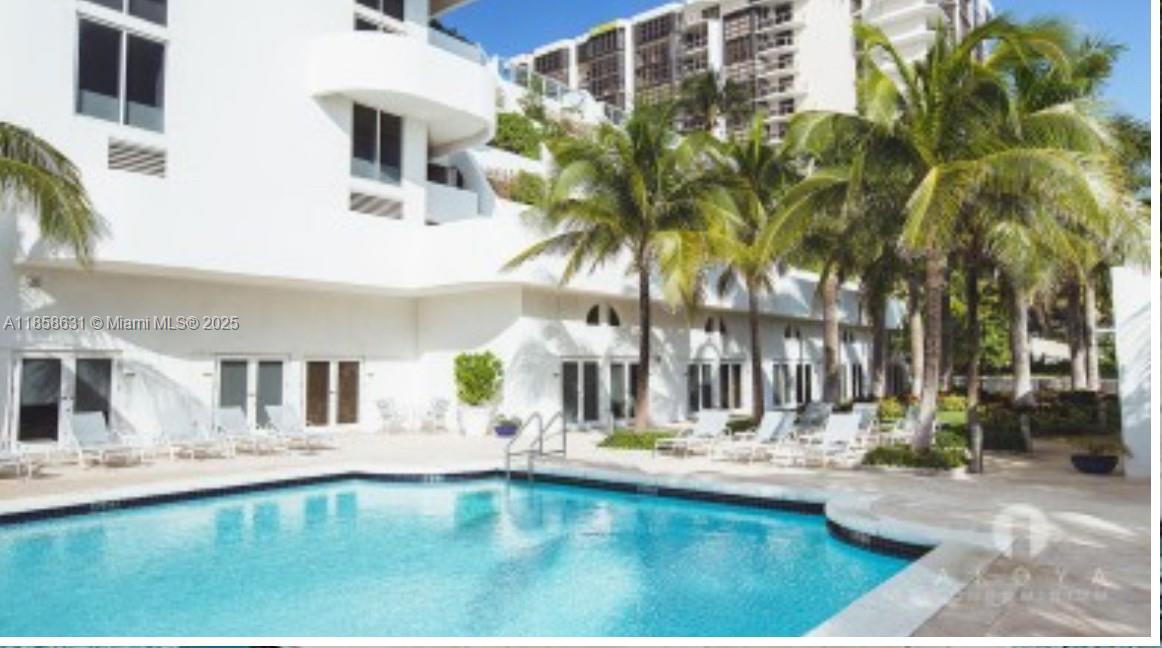 6365 Collins Avenue, Unit 2710 Miami Beach, FL 33141 - Photo 22 of 24 a view of swimming pool with palm trees