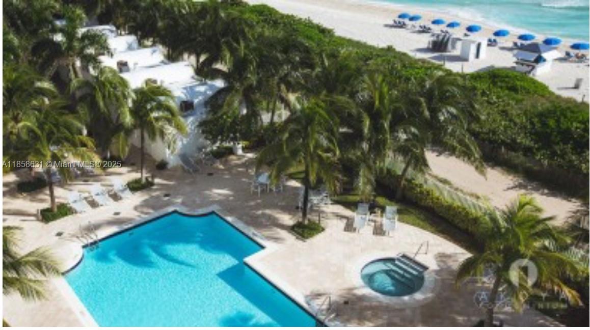 6365 Collins Avenue, Unit 2710 Miami Beach, FL 33141 - Photo 23 of 24 a backyard of a house with table and chairs