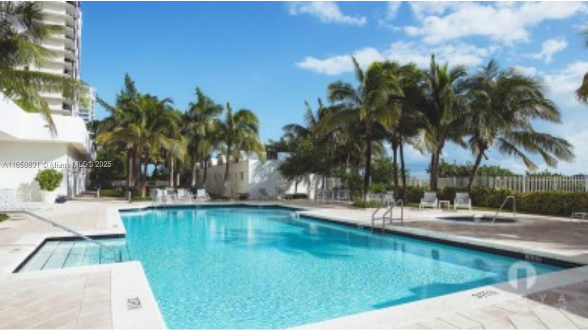 6365 Collins Avenue, Unit 2710 Miami Beach, FL 33141 - Photo 24 of 24 a view of a swimming pool with a lawn chairs under palm trees