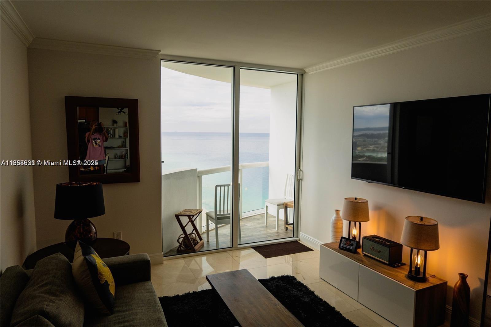 6365 Collins Avenue, Unit 2710 Miami Beach, FL 33141 - Photo 8 of 24 a living room with furniture and a flat screen tv