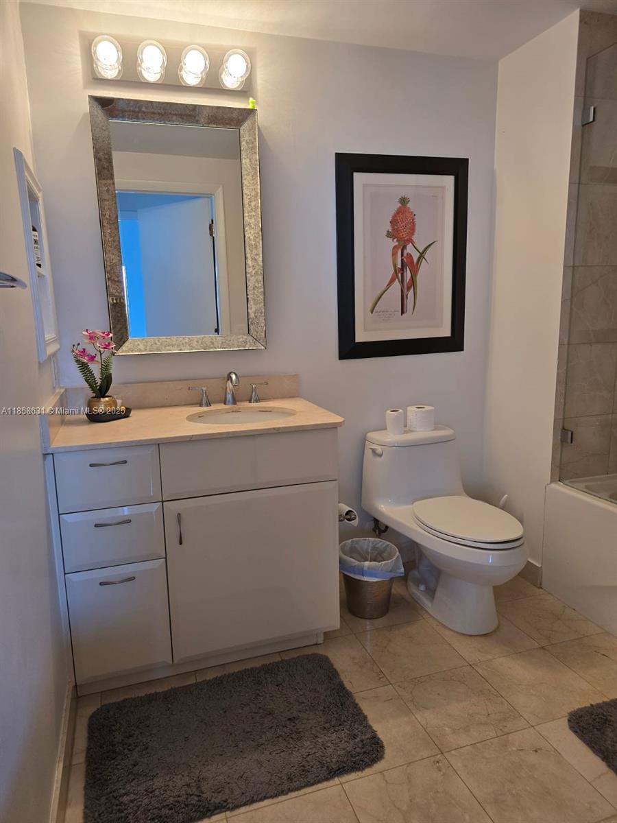6365 Collins Avenue, Unit 2710 Miami Beach, FL 33141 - Photo 10 of 24 a bathroom with a toilet a sink and mirror