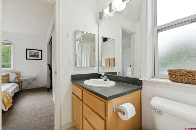 a bathroom with a granite countertop sink and a mirror