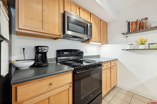 a kitchen with stainless steel appliances granite countertop a sink dishwasher stove and microwave with wooden floor