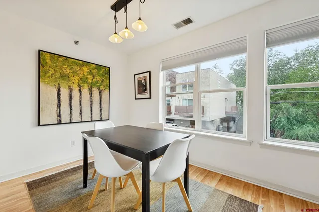 a dining room with wooden floor and a window