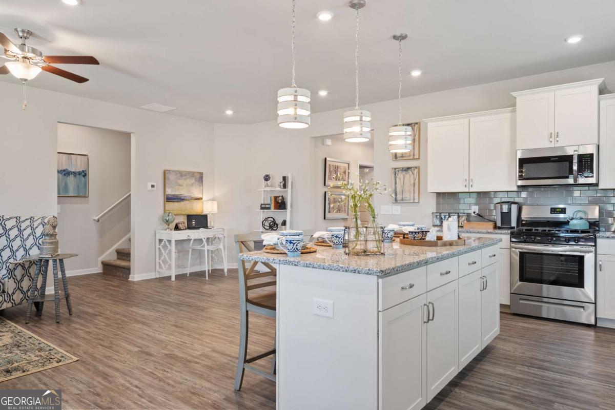 157 Creekside Road, Unit (LOT 32) Eatonton, GA 31024 - Photo 15 of 28 a kitchen with kitchen island granite countertop a sink cabinets and wooden floor
