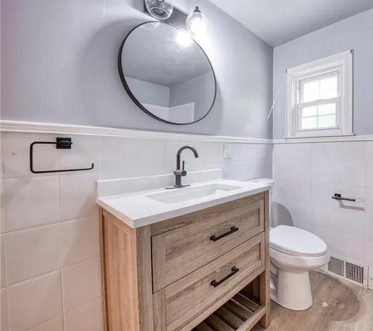 a bathroom with a toilet a sink and mirror