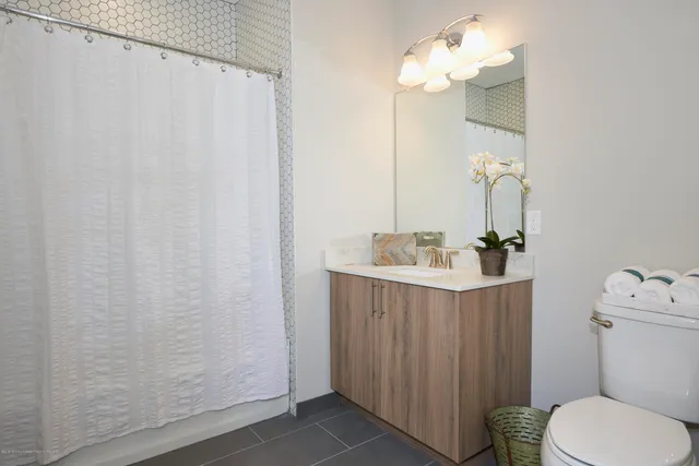 a bathroom with a sink mirror and toilet
