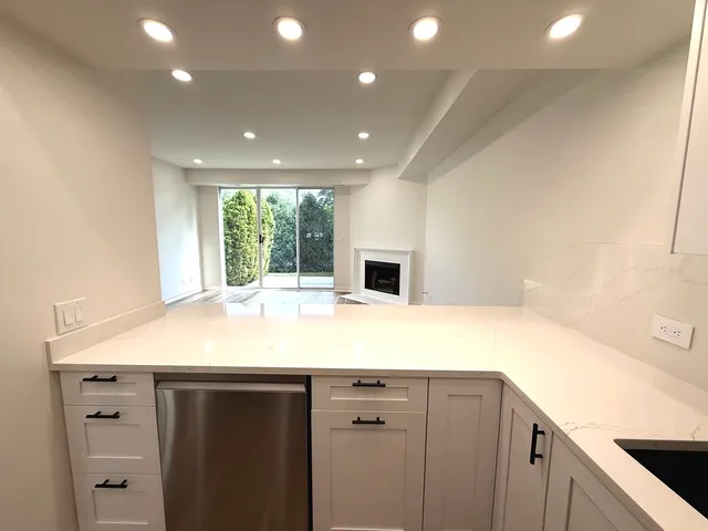 a kitchen with kitchen island a sink appliances and cabinets