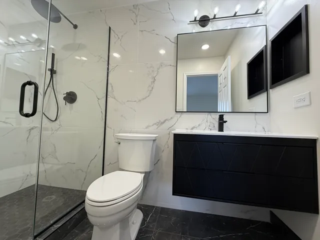 a bathroom with a sink a toilet and shower