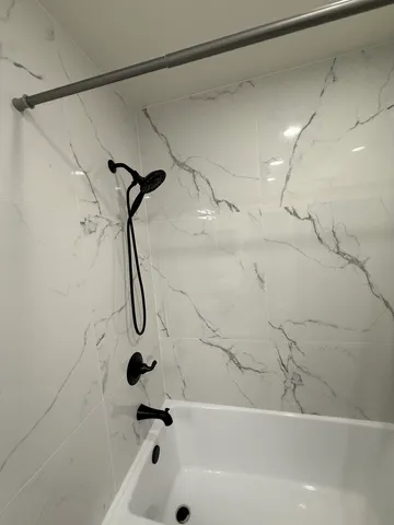 a bathroom with a bath tub with a shower