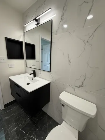 a bathroom with a toilet sink and mirror