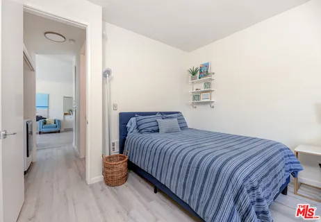 a bedroom with a bed and view of living room