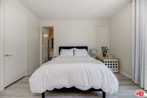 a bedroom with a bed and a potted plant